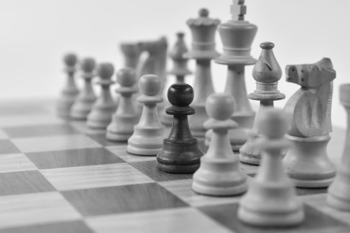 Close-up of chess pieces on a wooden board representing strategic chess training